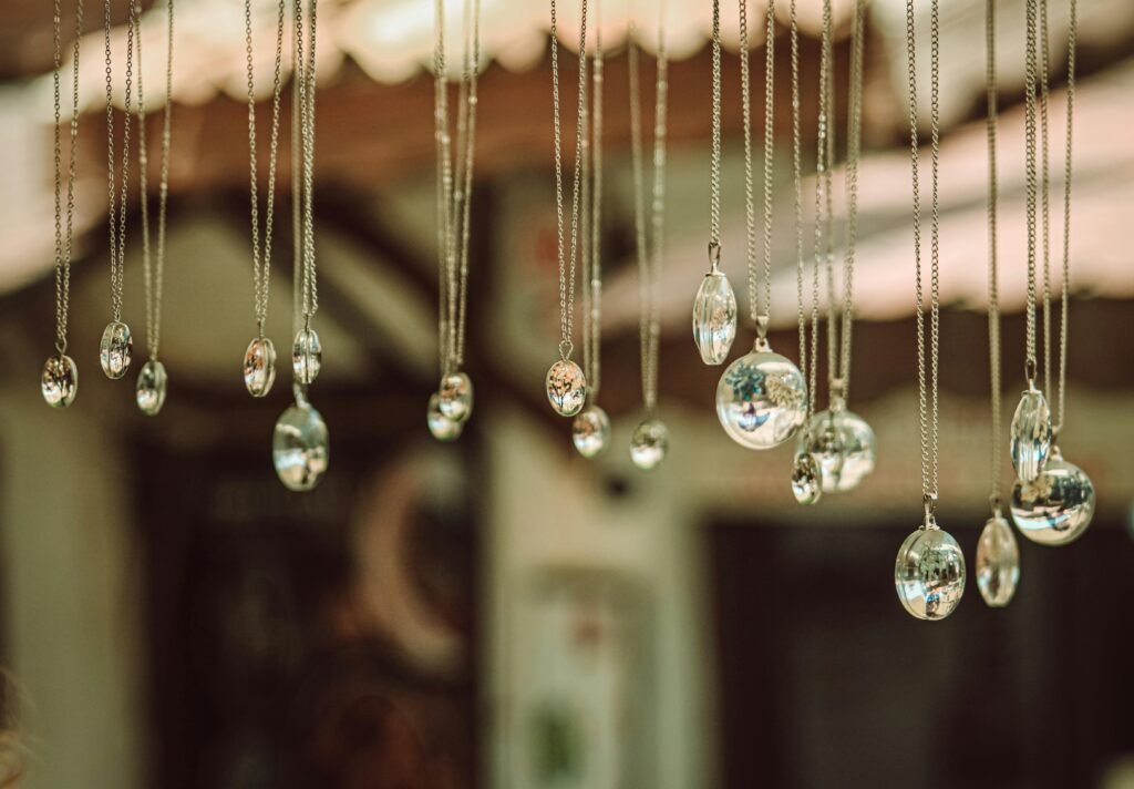 Close-up of hanging Gemstone pendants reflecting light in an artistic display. Silver Jewellery