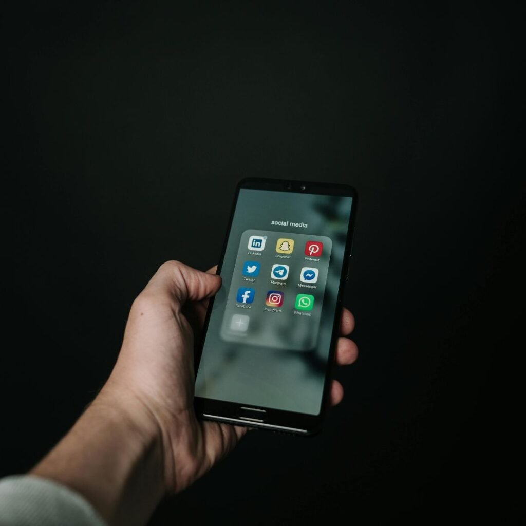 Digital marketer using smartphone with key social media platforms for online advertising and engagement