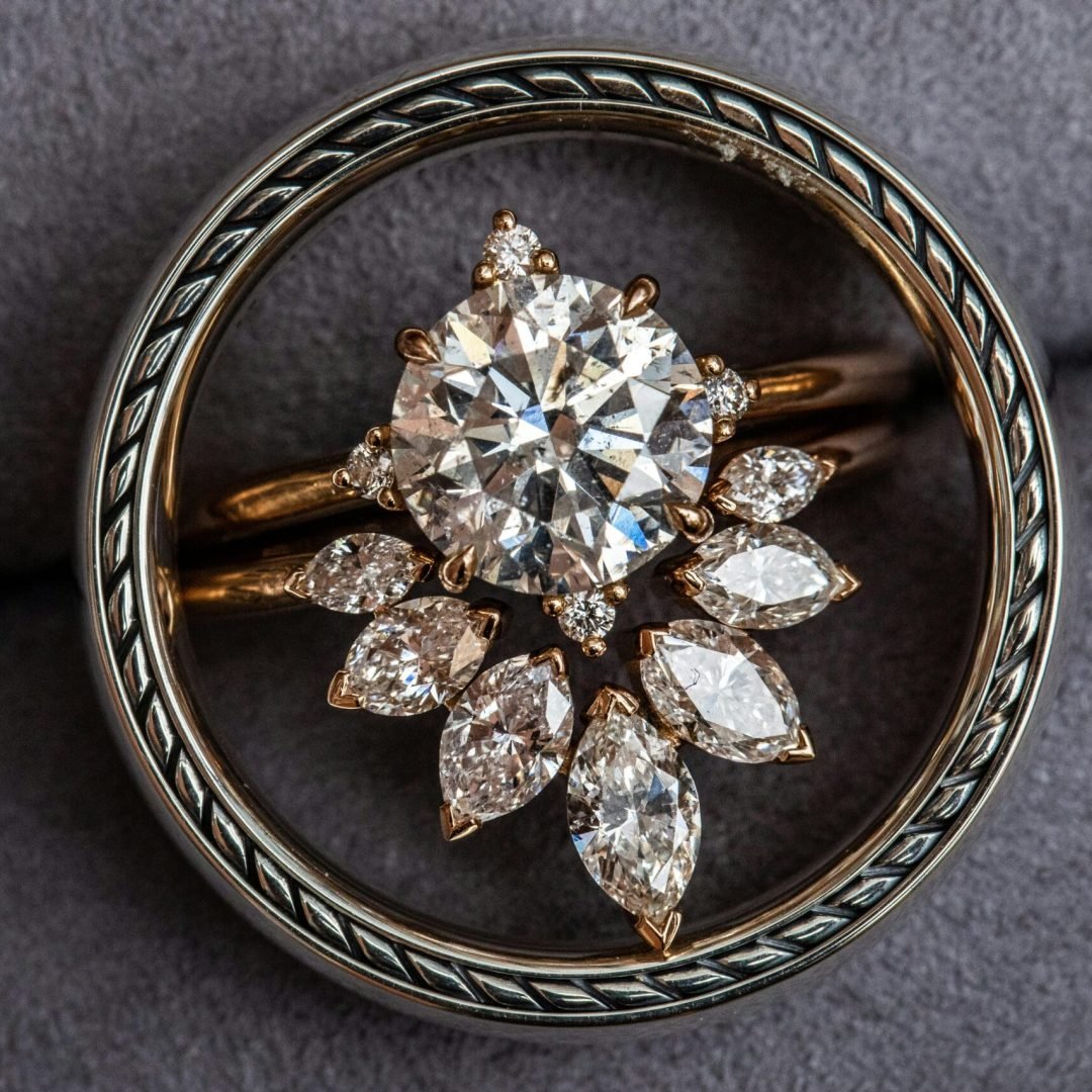 pexels-photo-15613452-15613452 Close-up of a stunning diamond ring with a floral brooch design, showcasing luxury jewelry.